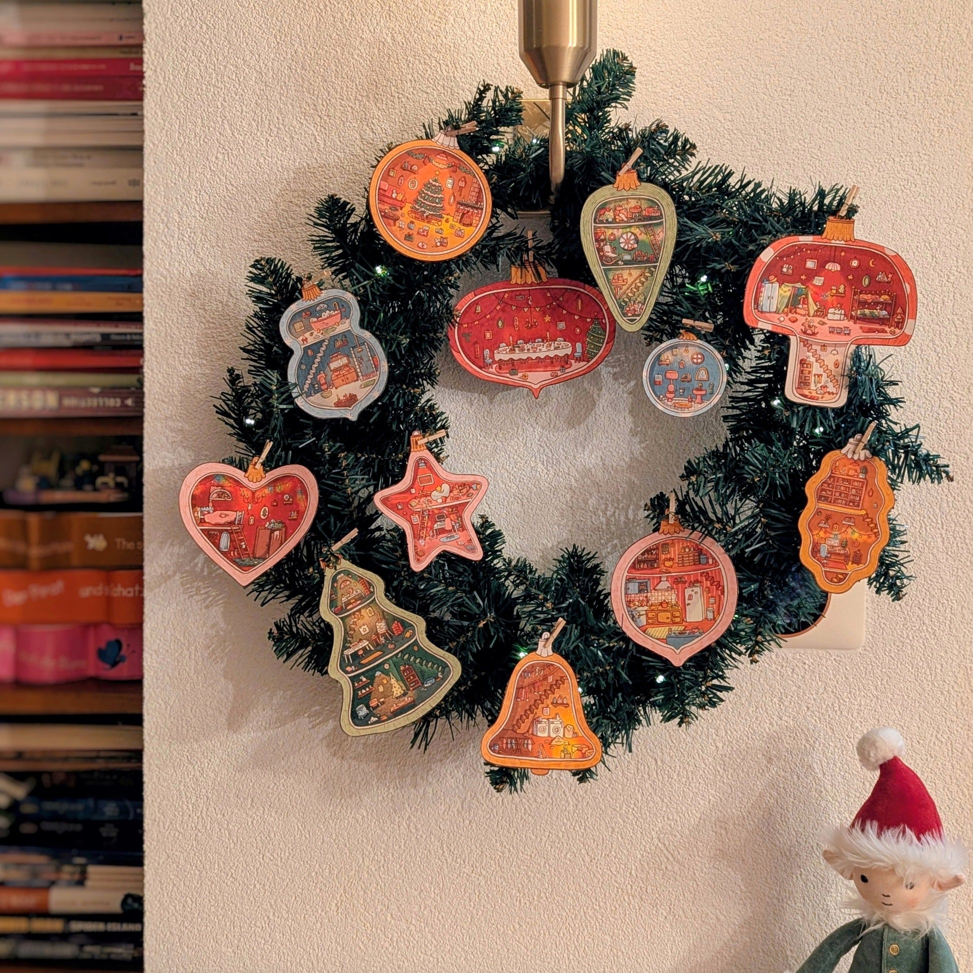 Cute Christmas wreath filled with printable paper ornaments illustrated by Lisa Manuels